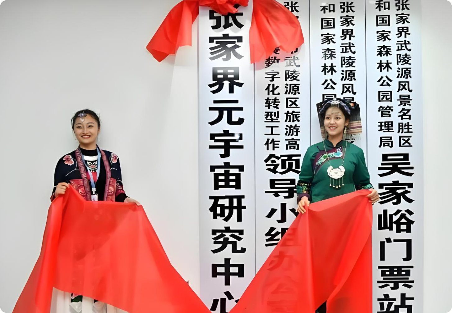图片展示了张家界武陵源风景名胜区吴家峪门票站的元宇宙研究中心揭牌仪式。画面中有两位身着民族服饰的女性，她们手持红色丝带，背景是竖排的黑色文字标识，其中“张家界武陵源风景名胜区”“吴家峪门票站”“张家界元宇宙研究中心”等字样清晰可见。该图片与上下文关系紧密，上下文提到2021年元宇宙概念火热，元宇宙方向包括VR硬件和区块链、智能合约技术编织的Web3去中心化世界，此图则展示了元宇宙在旅游领域的应用尝试。